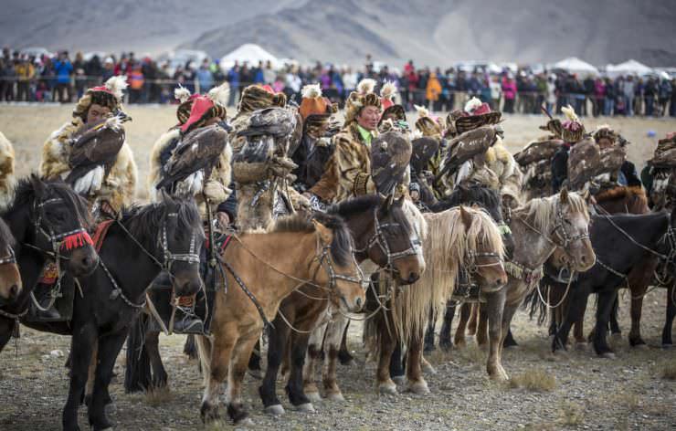 Eagle hunter riding a horse with his Altai Golden Eagle