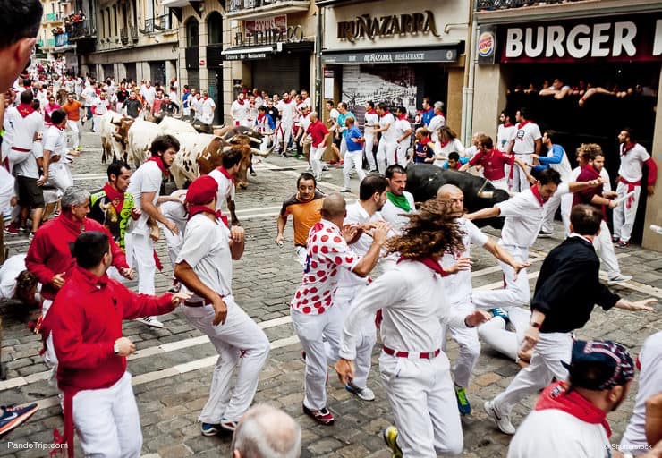 Bulls and people are running in street during San Fermin festival