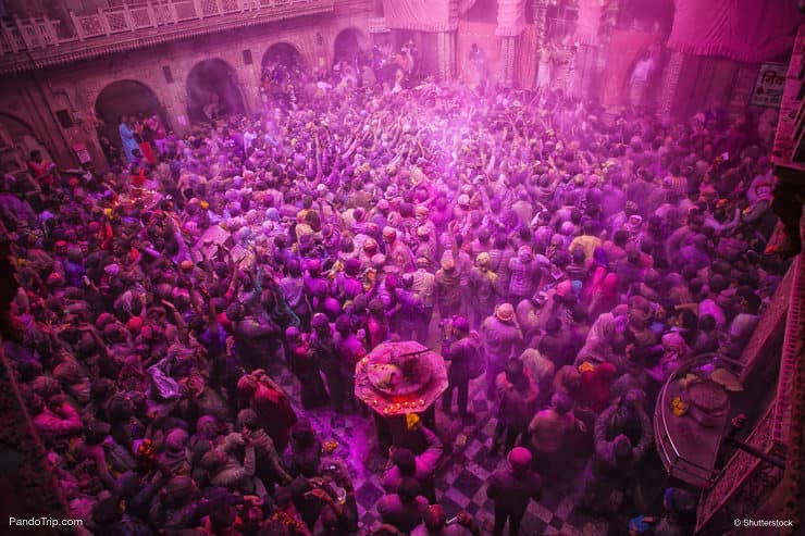 People throw colors to each other during the Holi celebration at Krishna temple in Nandgaon, India