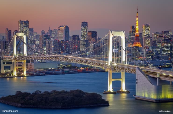 Rainbow Bridge and Tokyo tower in the background at night. Odaiba, Japan