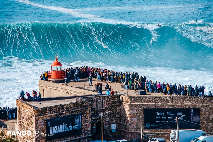 Gigantic waves against the iconic red lighthouse in Nazare