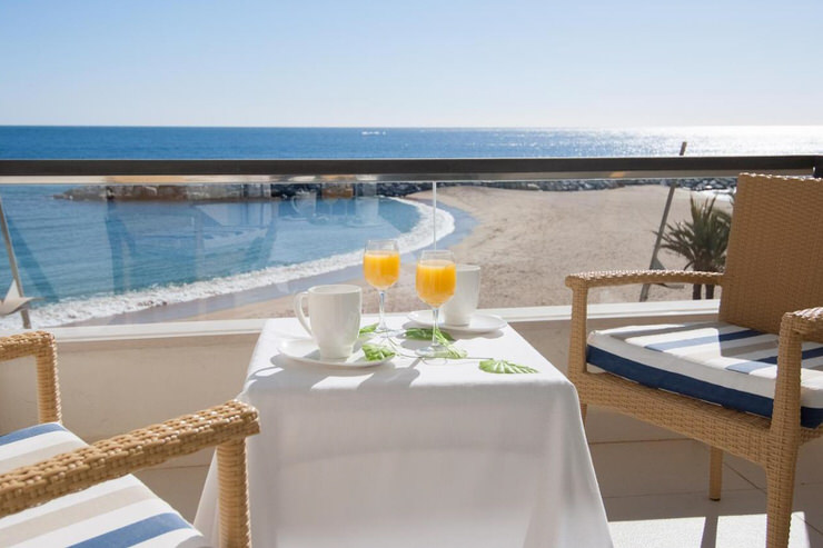 Balcony at Hotel Rosamar in Sant Antoni de Calonge overlooking a quiet sandy beach and the calm, blue Mediterranean Sea