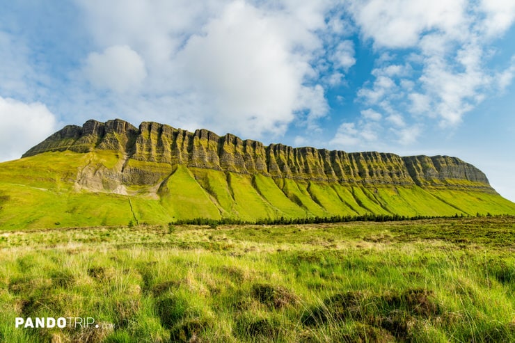View from the valley of Benbulbin’s stratified cliffs and vibrant green meadows in Ireland