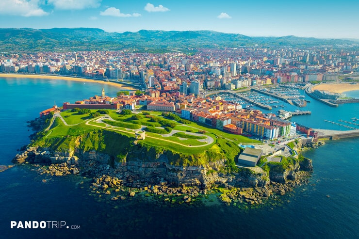 Gijón cityscape with marina, coastline, and Cimavilla historic district surrounded by blue sea