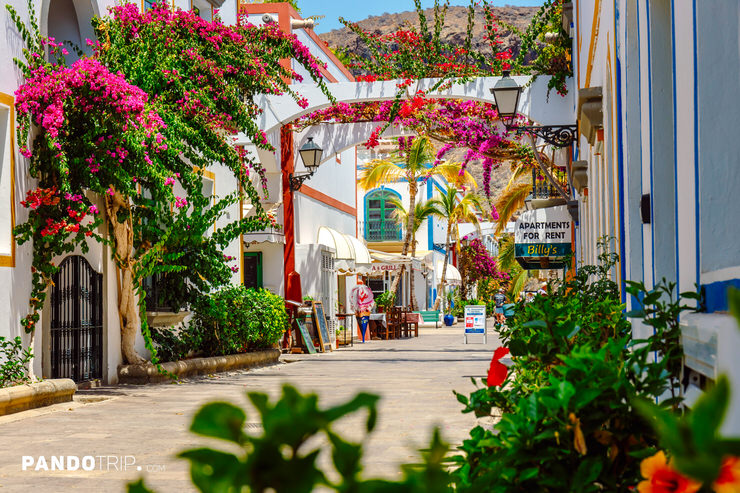 Bougainvillea-lined pedestrian street in Puerto de Mogán with whitewashed buildings