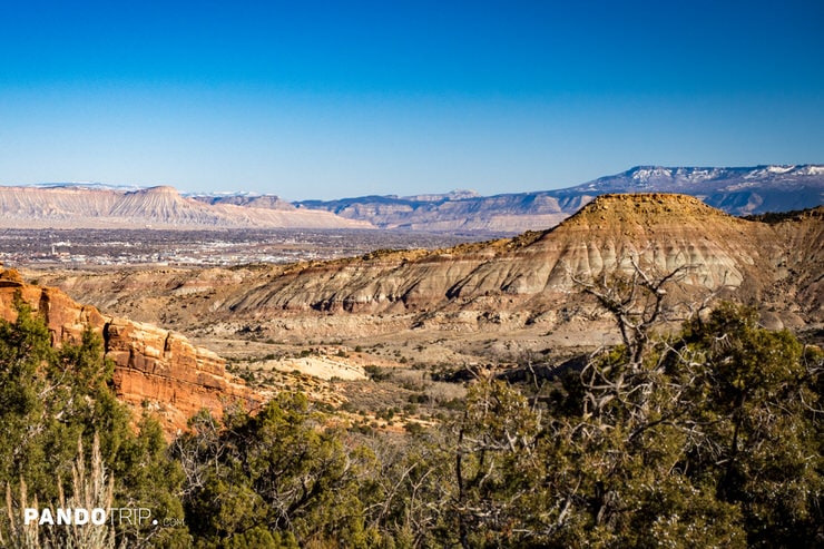 Scenic view of buttes and mesas near Grand Junction with Grand Mesa’s snowy ridgeline beyond