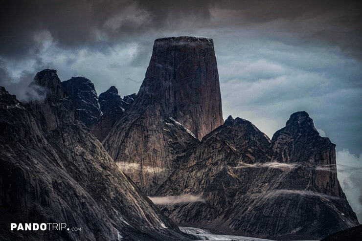 Dark, moody view of Mount Asgard surrounded by mist and jagged Arctic peaks