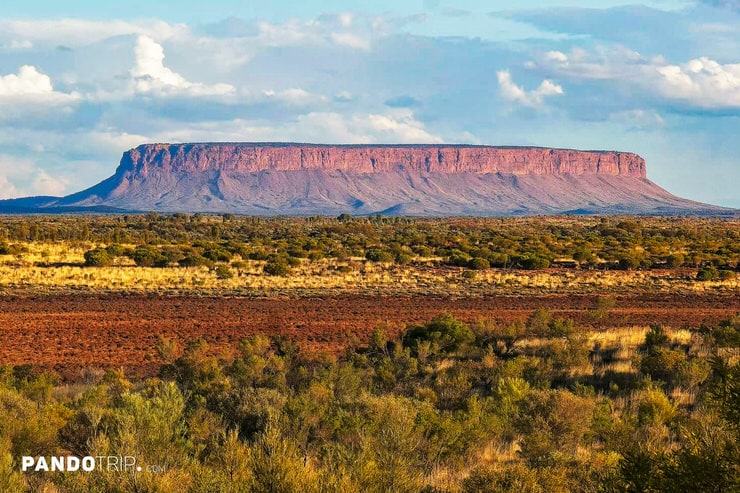 Wide view of Mount Conner with its flat summit and red sandstone cliffs in the Outback