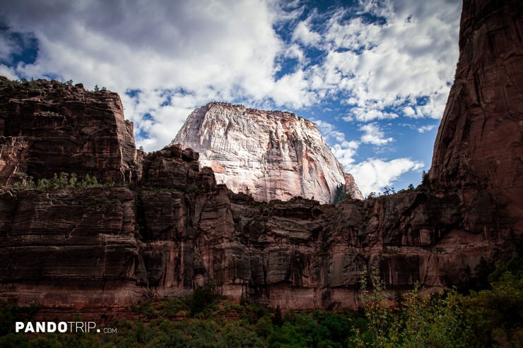 The Great White Throne rises above the canyon, framed by dark rock walls and a cloudy sky in Zion National Park