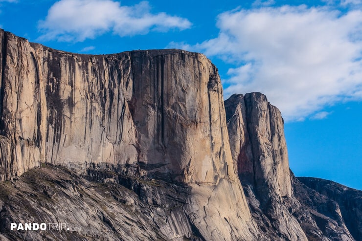 Close-up of Mount Asgard’s sheer granite cliffs under a blue sky in Nunavut, Canada