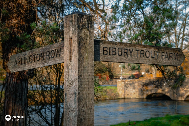 Wooden signpost pointing to Arlington Row and Bibury Trout Farm