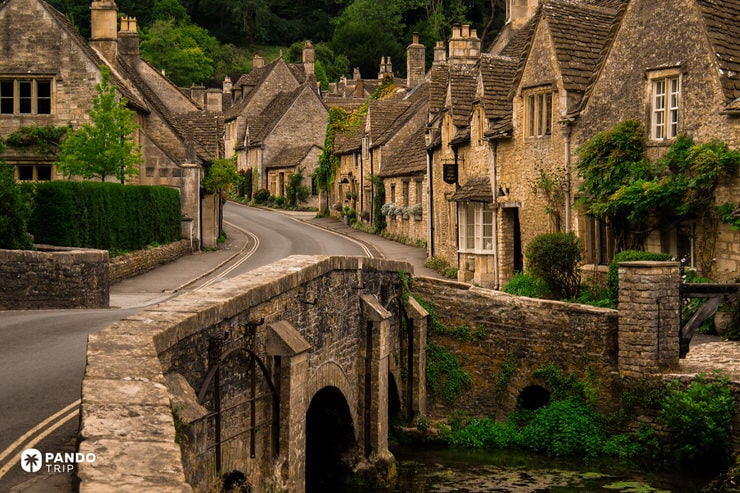 Stone bridge leading into Bibury’s main street lined with Cotswold houses