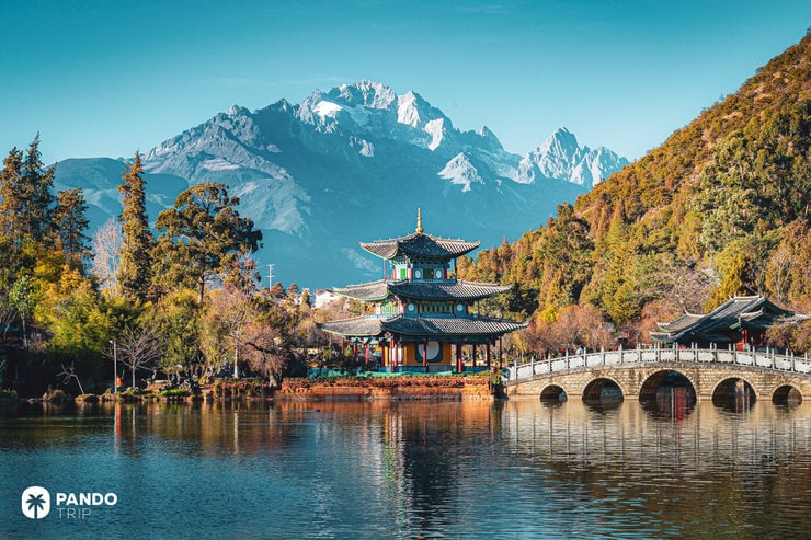 Traditional Chinese pavilion by Black Dragon Pool with Jade Dragon Snow Mountain in the background