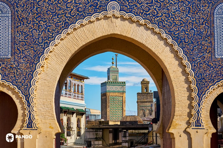 Intricate view of the Blue Gate arch framing mosque minarets in the old medina of Fes el-Bali