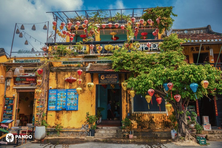 Colorful paper lanterns decorating a yellow colonial house in the old town of Hoi An, Vietnam