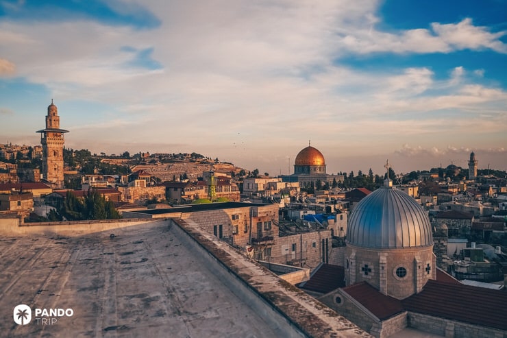 Sunset view over Jerusalem’s Old City rooftops with the Dome of the Rock and church domes in the background