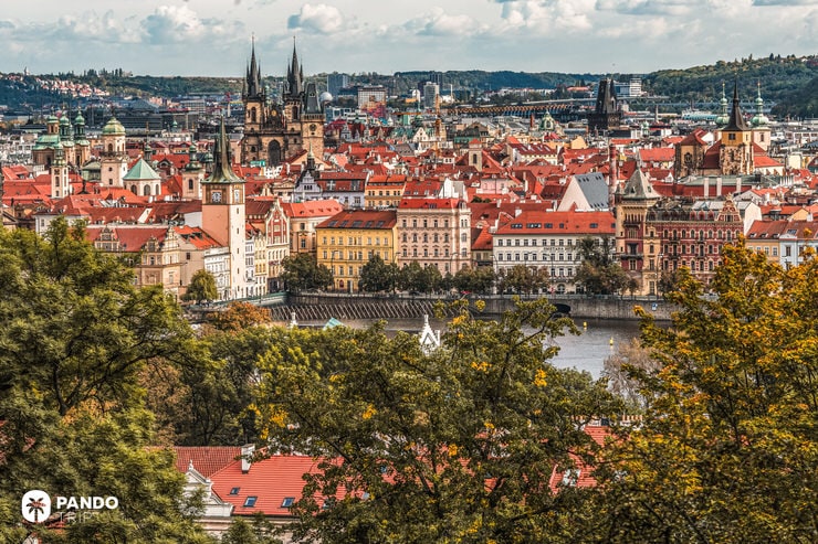 Colorful buildings and church spires of Prague’s Old Town seen from across the Vltava River