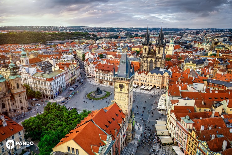 Aerial photo of Prague’s Old Town Square with red rooftops, gothic Týn Church, and historic buildings