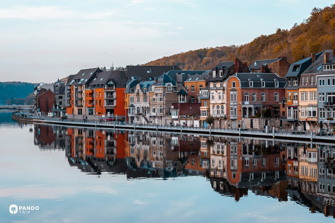Colorful riverfront houses reflected in the Meuse, Dinant, Belgium