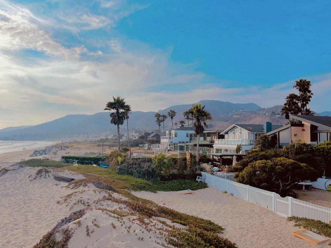 Beachfront luxury homes on Broad Beach in Malibu protected by sand dunes and vegetation.