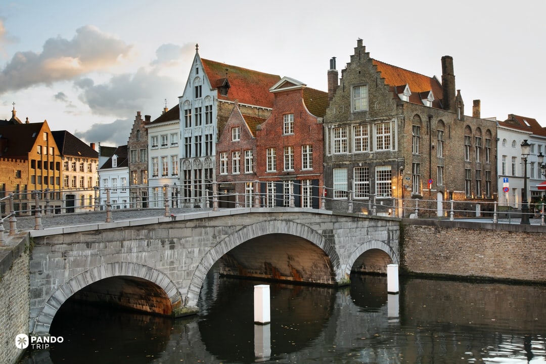 Stone bridge over a canal with stepped-gabled houses in Bruges’ historic centre