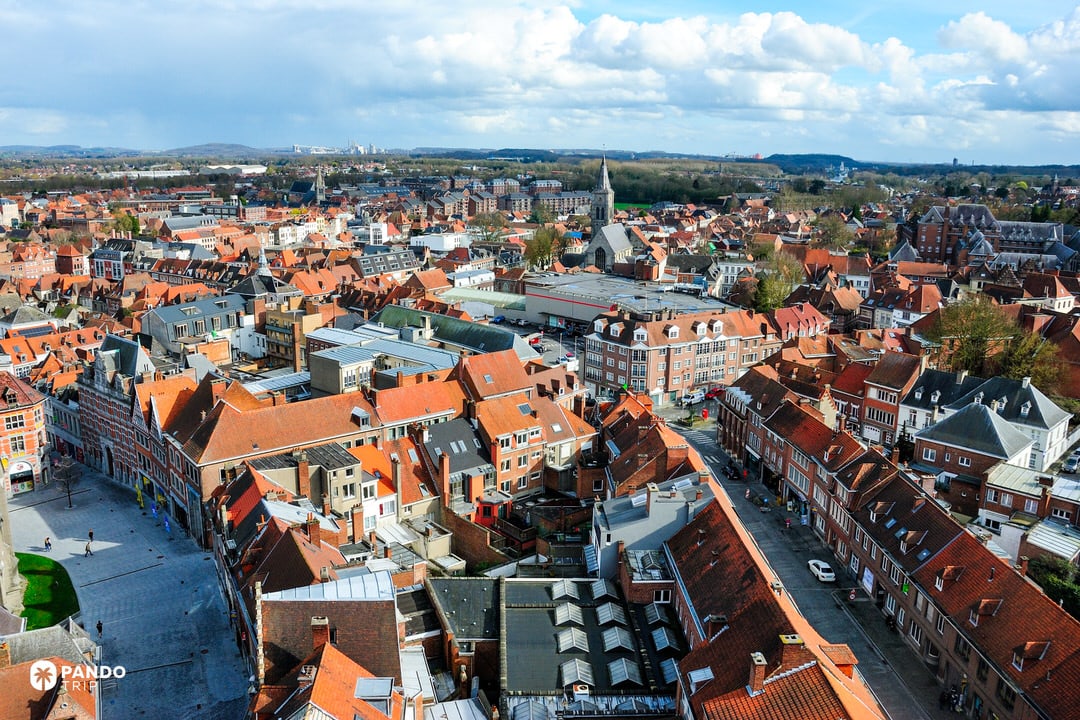 Riverside view in Tournai with historic church and brick façades along the Escaut
