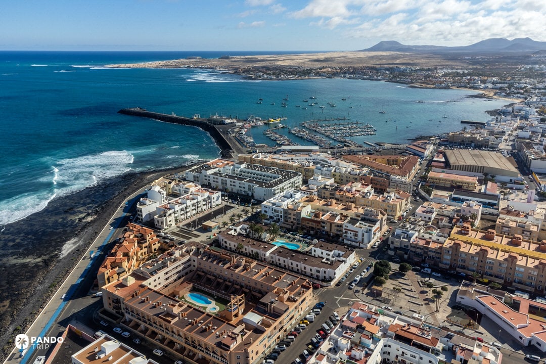 Aerial of Corralejo town and marina on Fuerteventura’s north coast, gateway to Popcorn Beach and the dunes.
