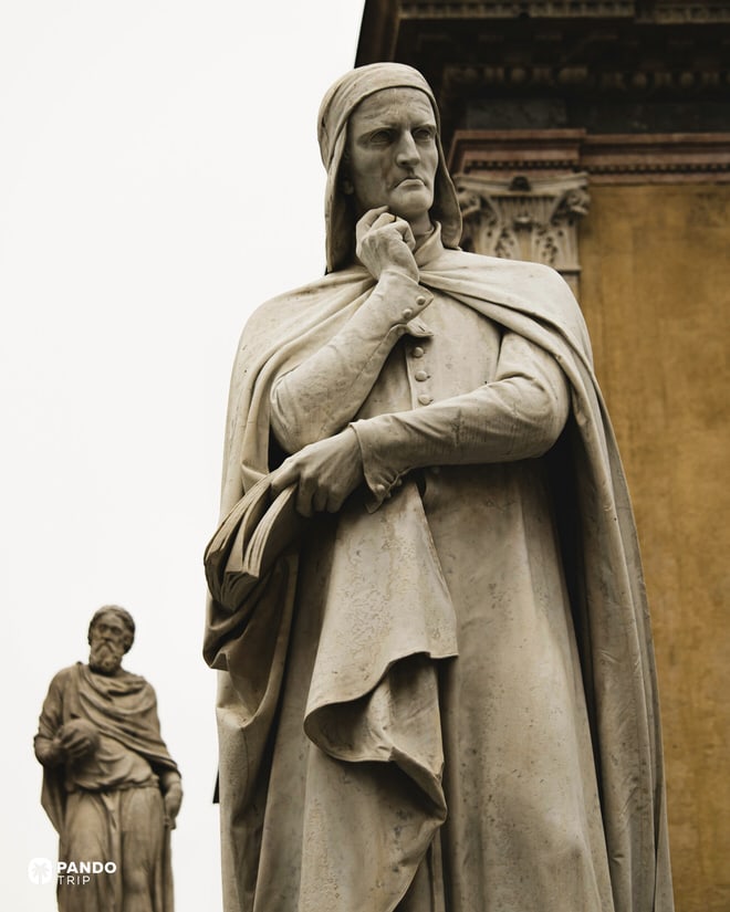 Low-angle shot of the Dante Alighieri statue in Piazza dei Signori, Verona, showing his pensive expression.