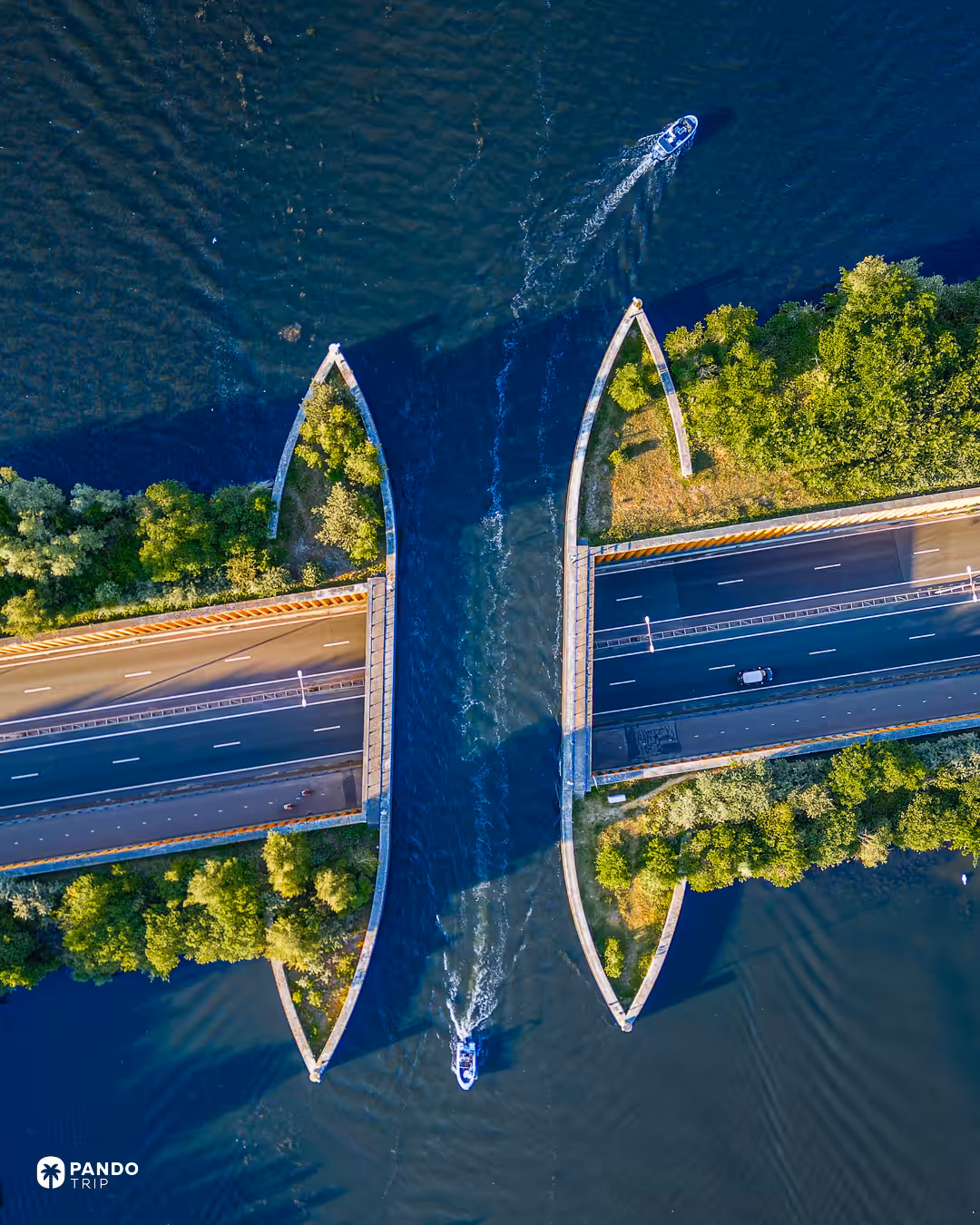 Directly overhead view of the Aquaduct Veluwemeer at low sun, two small motorboats passing along the water channel that crosses the N302.
