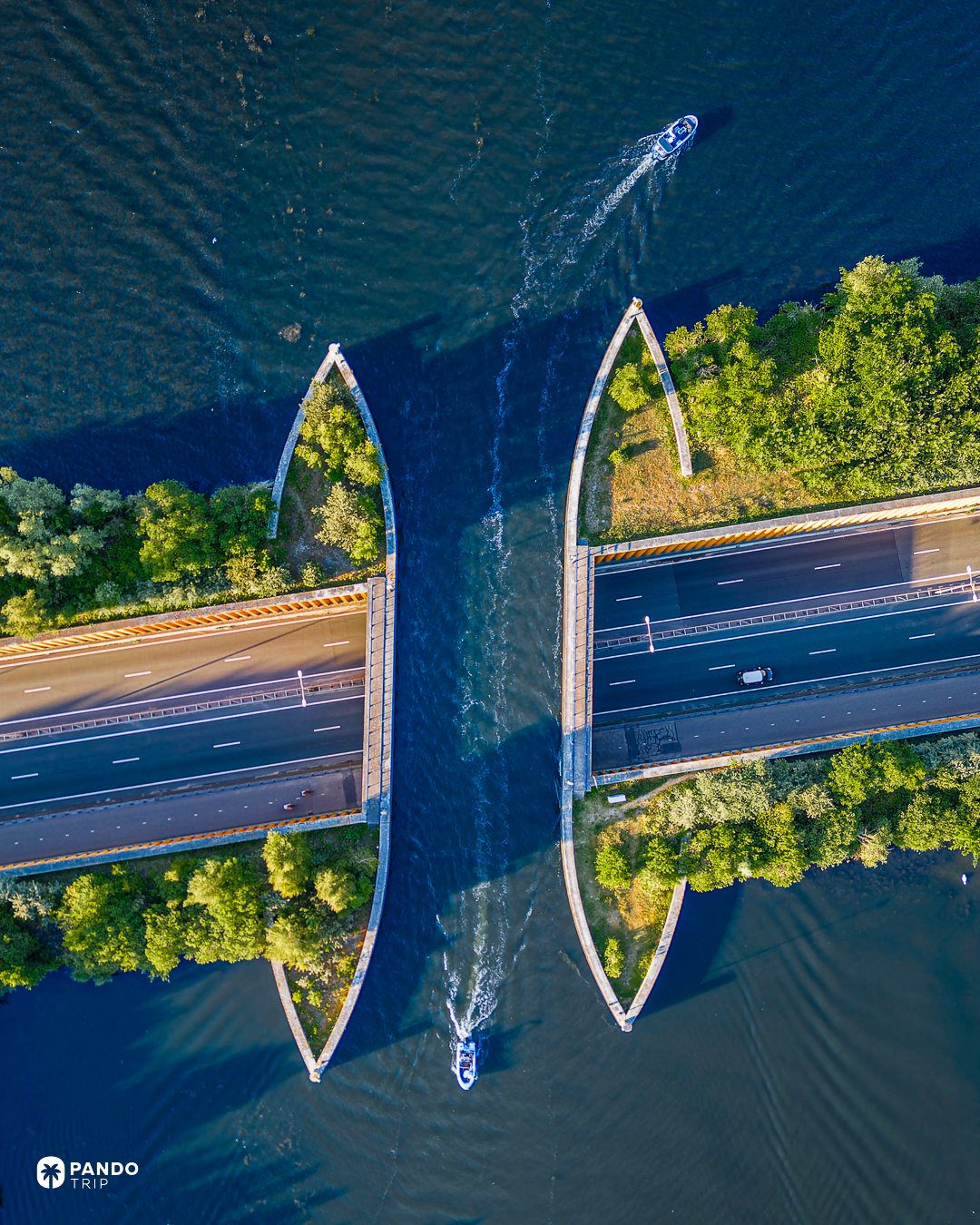 Directly overhead view of the Aquaduct Veluwemeer at low sun, two small motorboats passing along the water channel that crosses the N302.