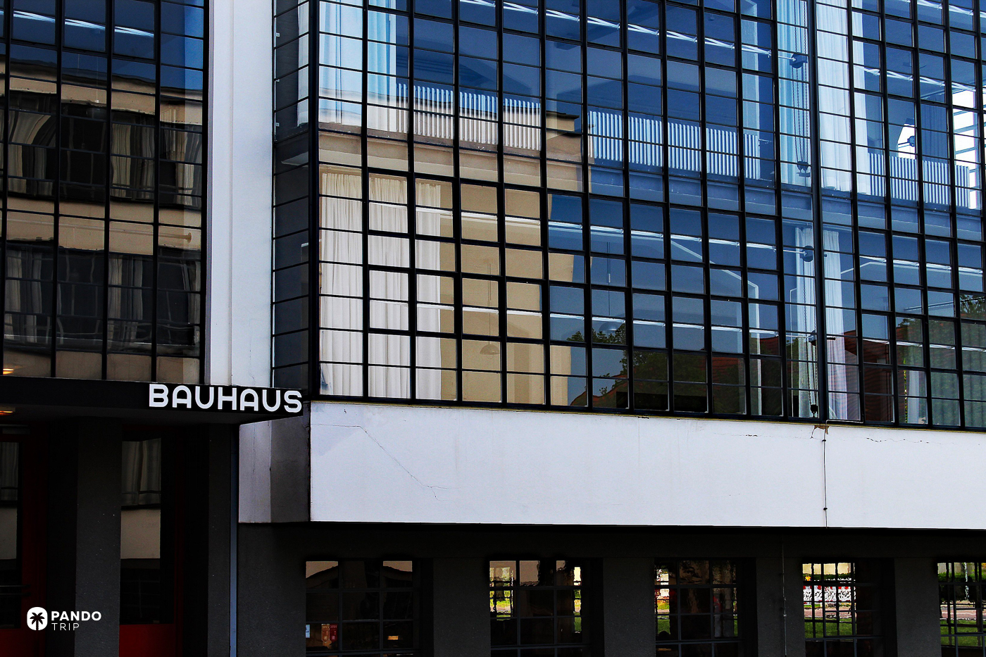 The glass curtain wall of the Bauhaus workshop wing in Dessau, with white BAUHAUS lettering on the flank.