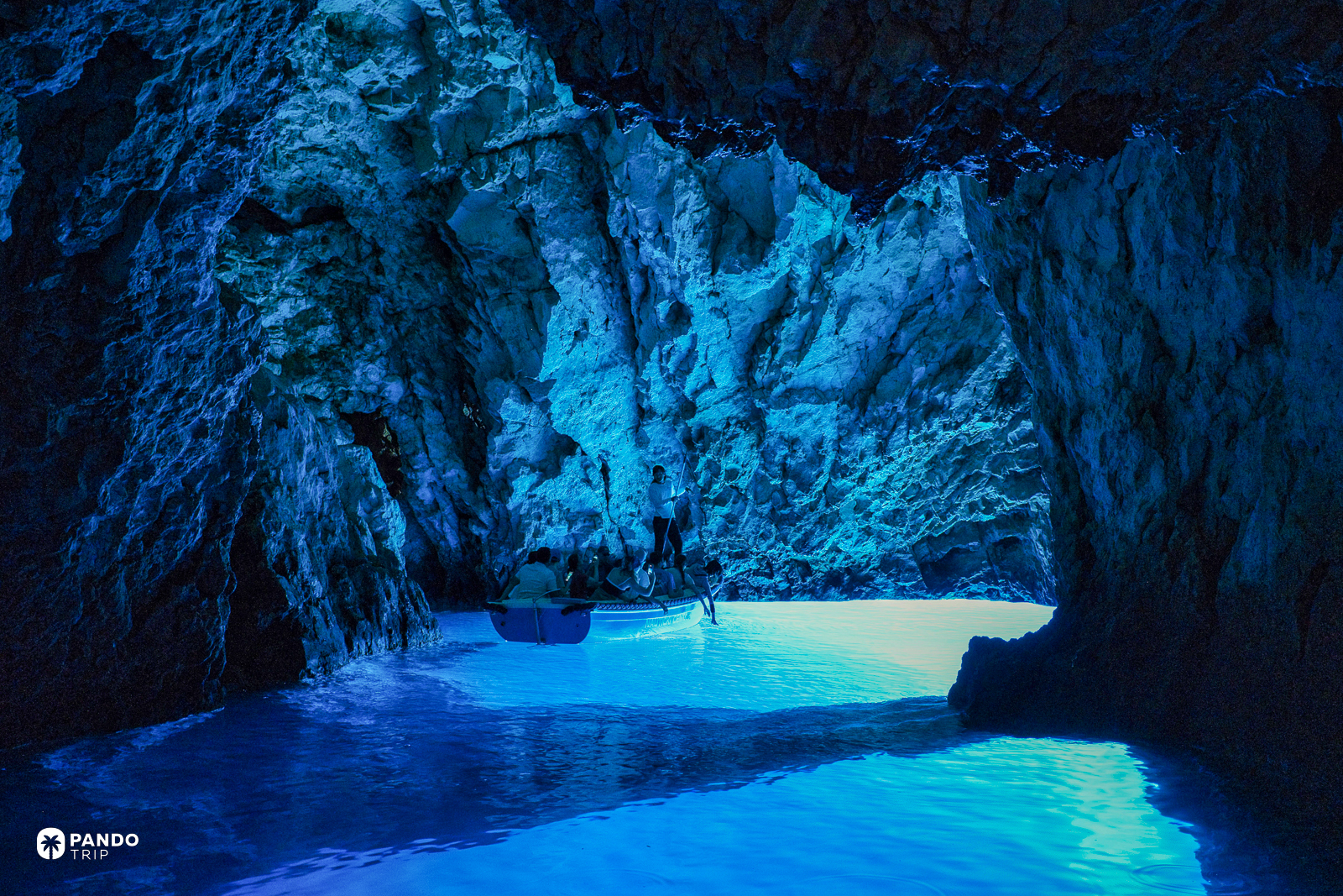 The Blue Cave on Bisevo, a small boat on water glowing blue from below.