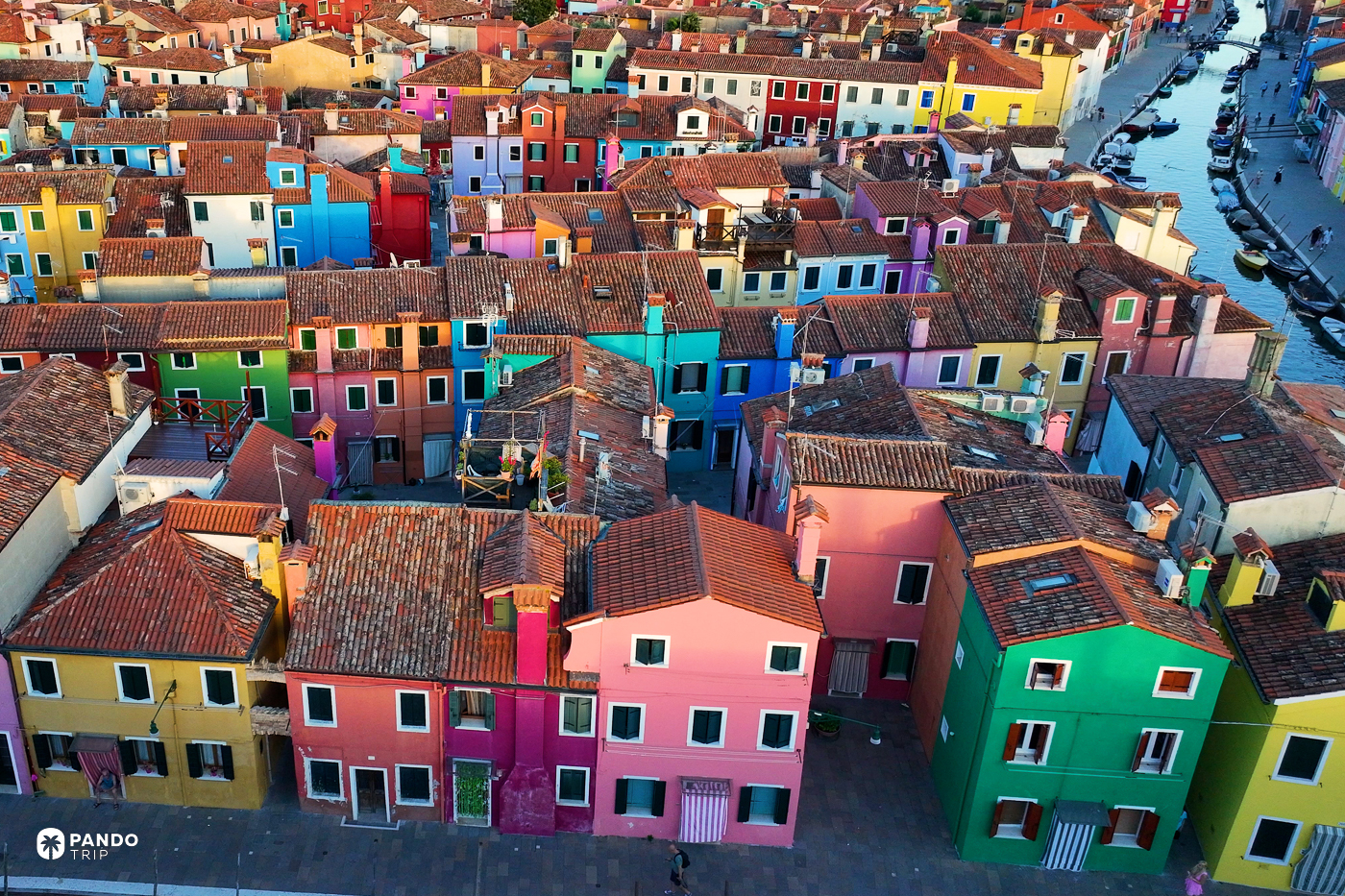 Painted facades and terracotta roofs packed together on Burano.