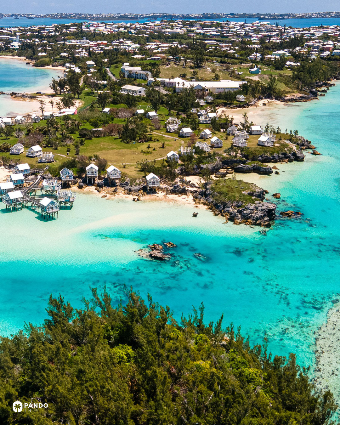 White-roofed cabins on stilts over turquoise shallows at Daniel's Head, Sandys Parish, Bermuda.