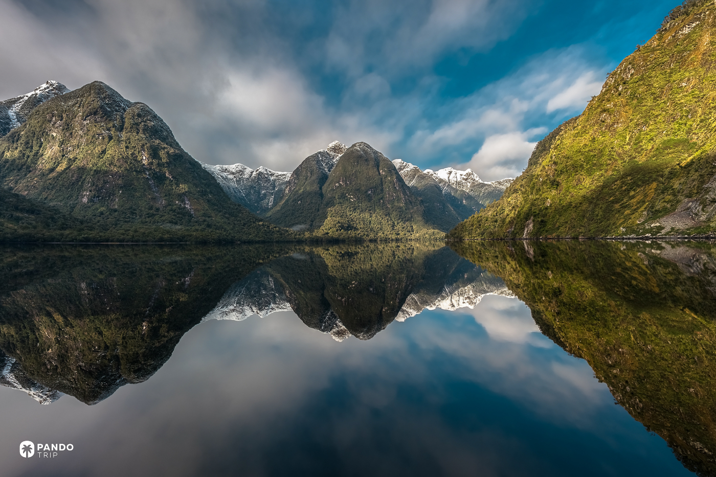 Doubtful Sound's still water reflecting the peaks around it.