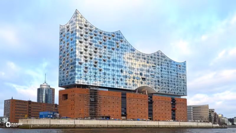 The curved glass roofline of the Elbphilharmonie above the red-brick Kaispeicher on the Elbe in Hamburg.