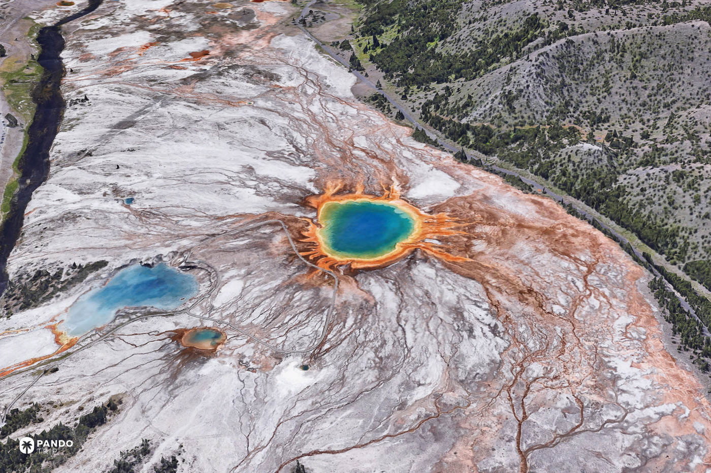 Satellite view of Grand Prismatic Spring in Yellowstone, its blue centre ringed with orange runoff beside the Firehole River.
