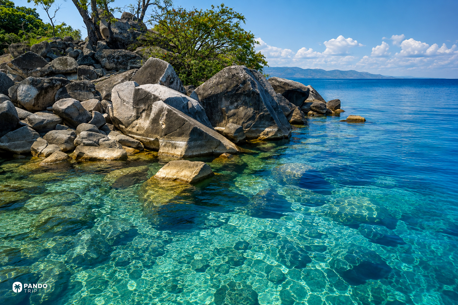 Granite boulders and clear shallow water at the shore of Lake Malawi.