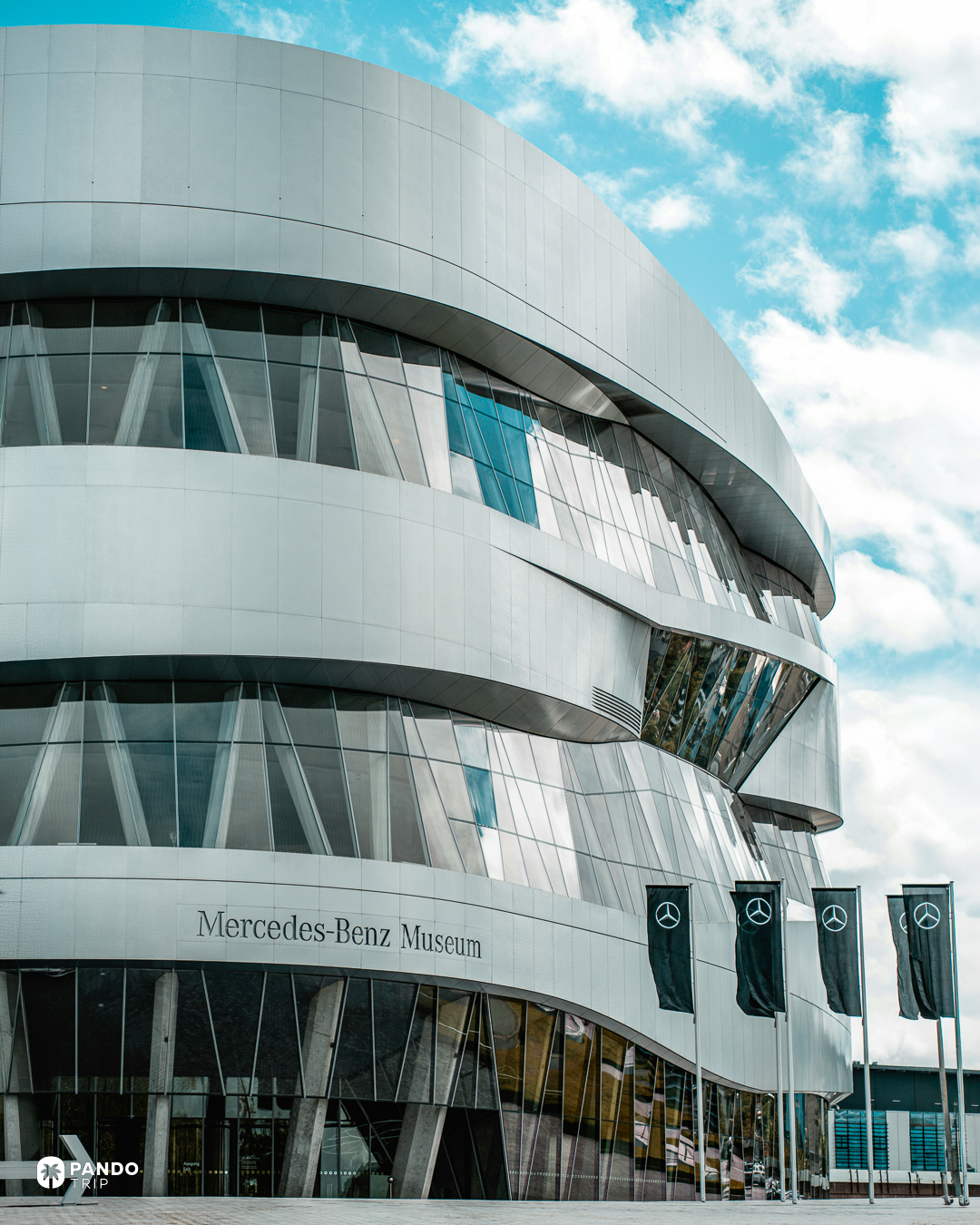 Twisting glass and aluminium bands on the Mercedes-Benz Museum facade above the entrance lettering.