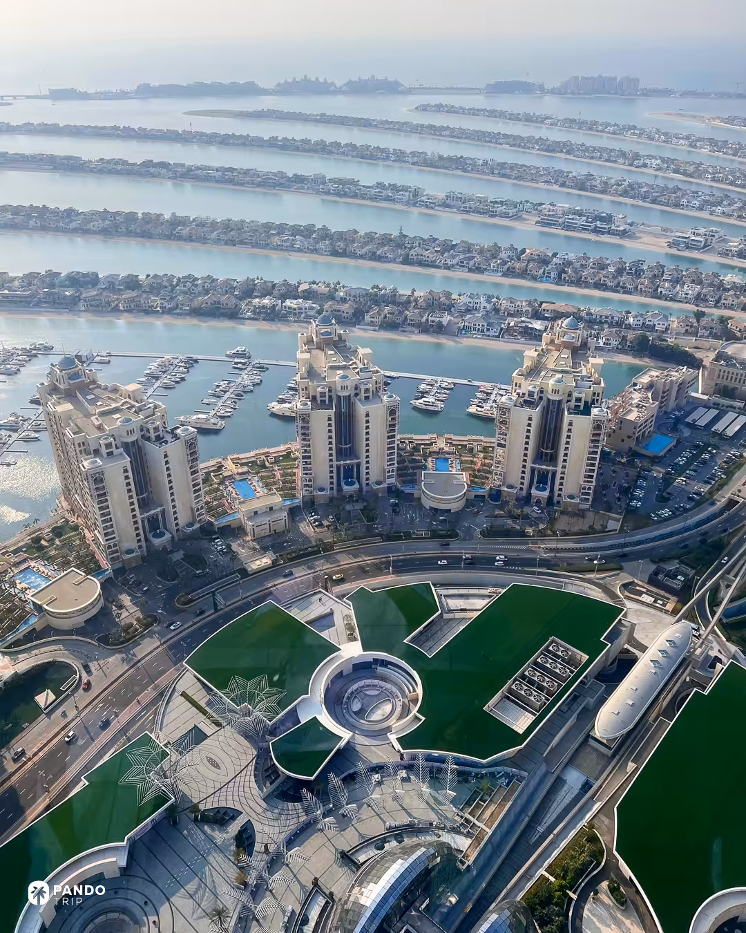 Apartment towers and marinas on Palm Jumeirah, with the fronds and open sea beyond.
