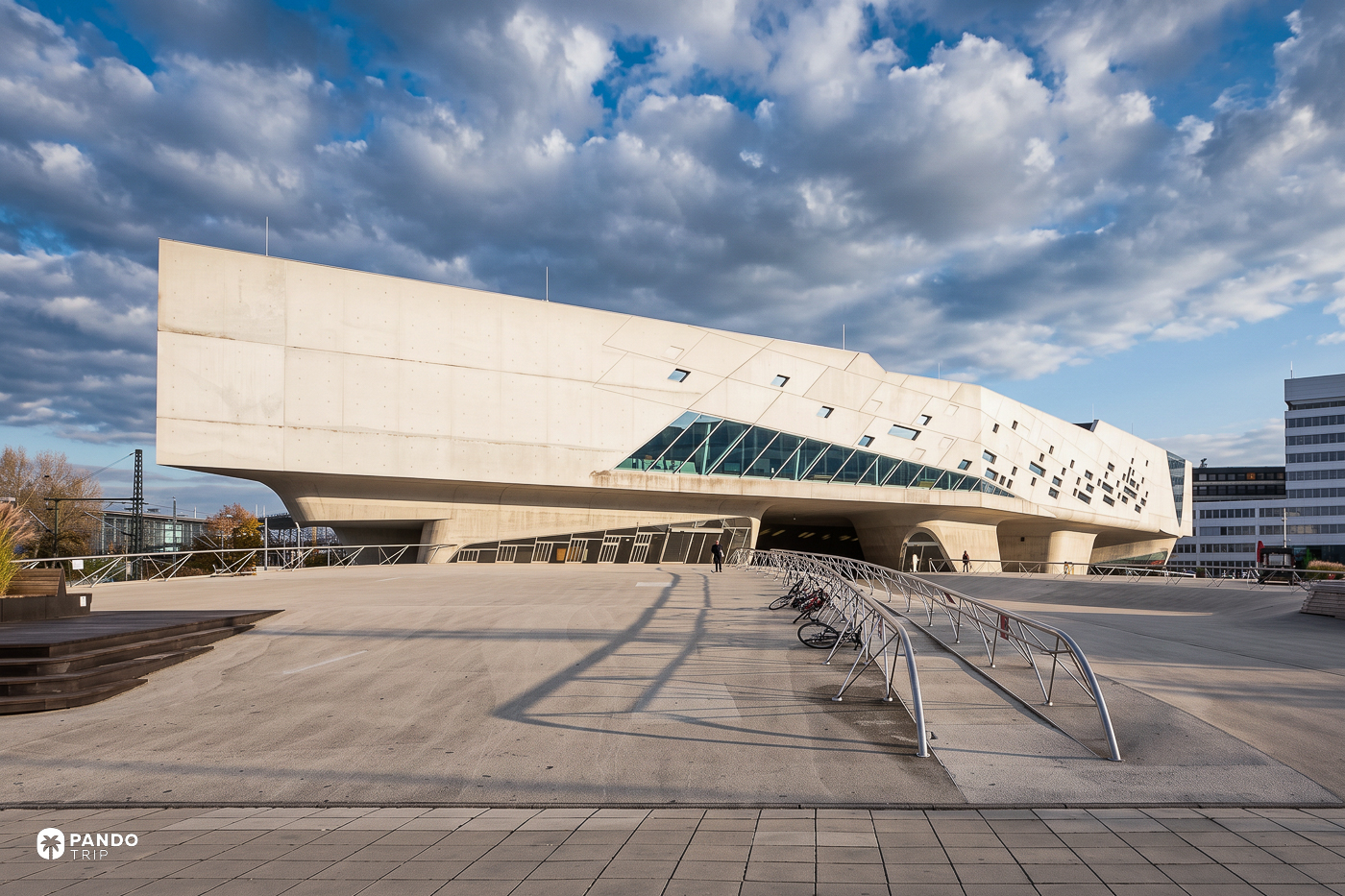phaeno in Wolfsburg lifted on its concrete cones above an open plaza, bicycle racks in the foreground.