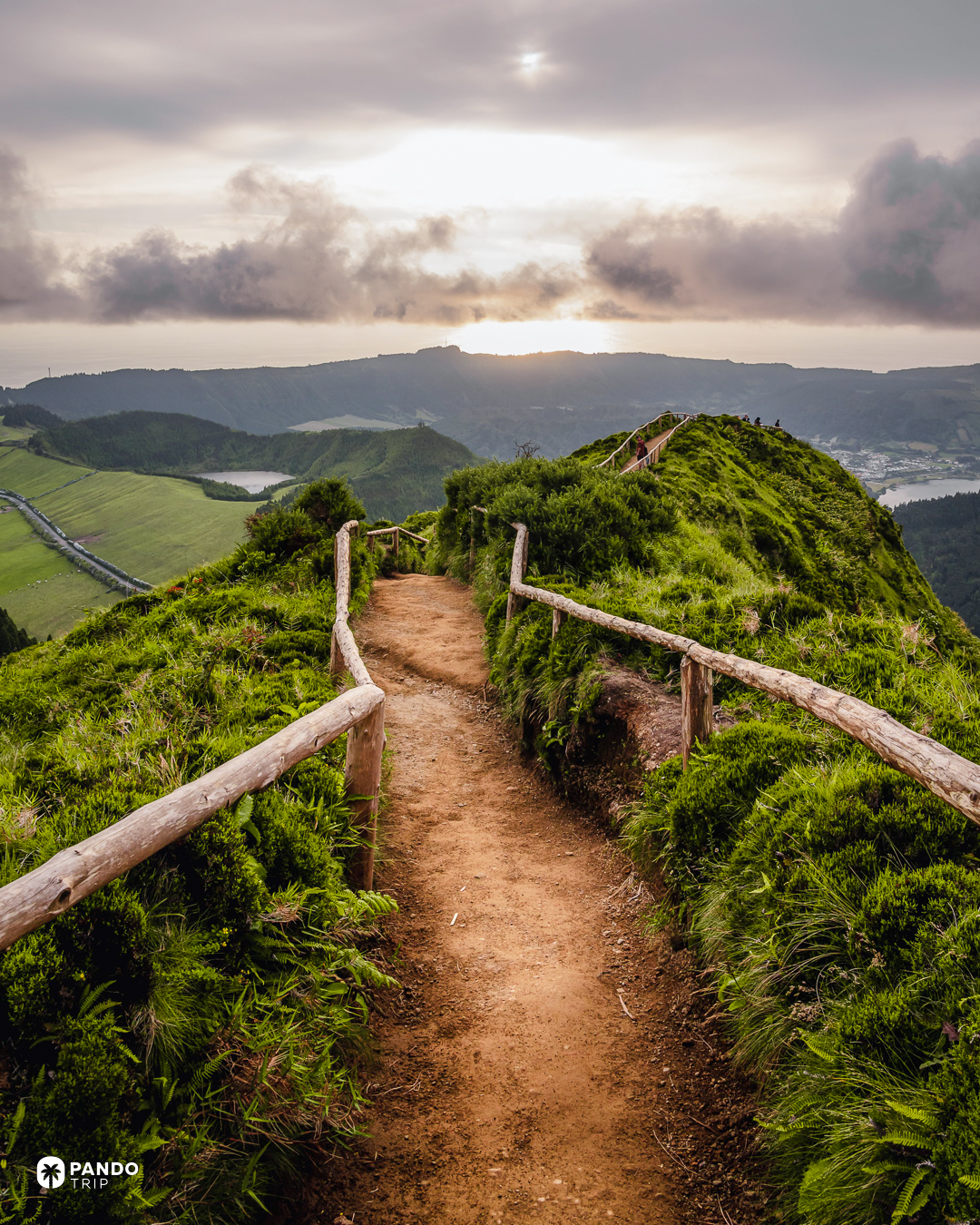 A fenced ridge path above the crater lakes of Sete Cidades at sunset, Sao Miguel, Azores.