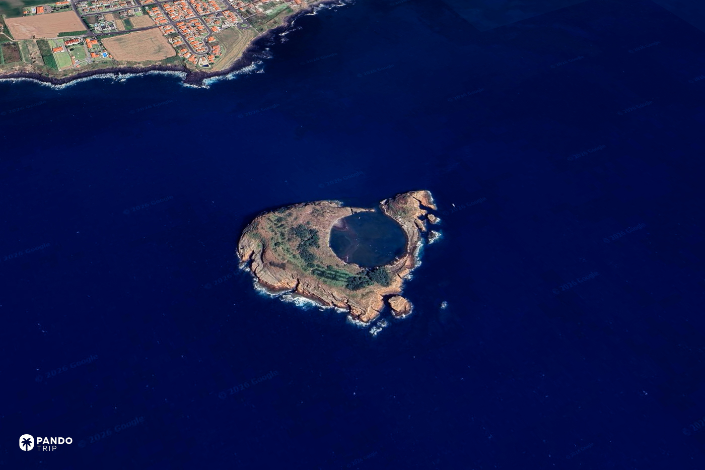 Satellite view of the Vila Franca islet off Sao Miguel, a ring of rock enclosing a circular pool in deep blue water.