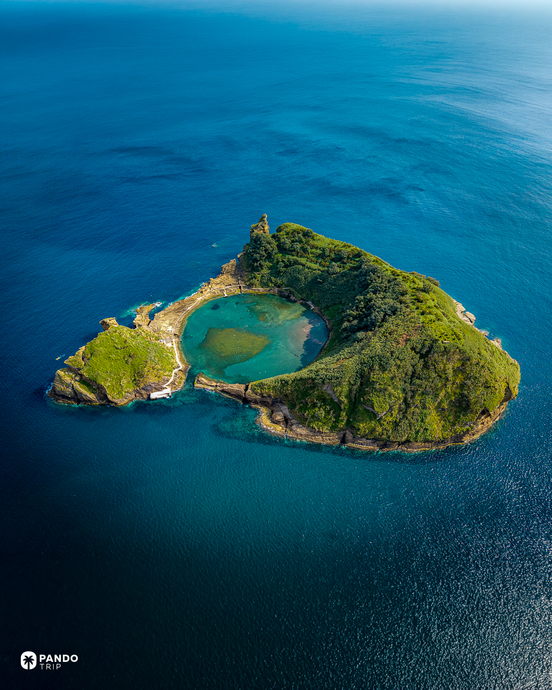 The flooded crater of Vila Franca islet, ringed by green cliffs in deep blue water off Sao Miguel, Azores.