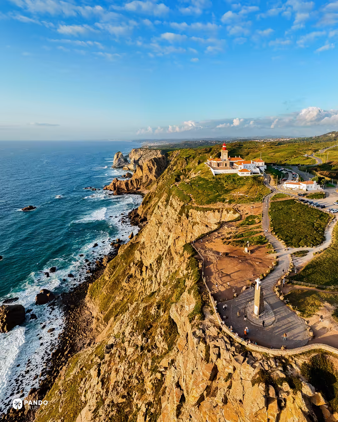 Cabo da Roca lighthouse and stone monument on the cliffs, with the coast running north