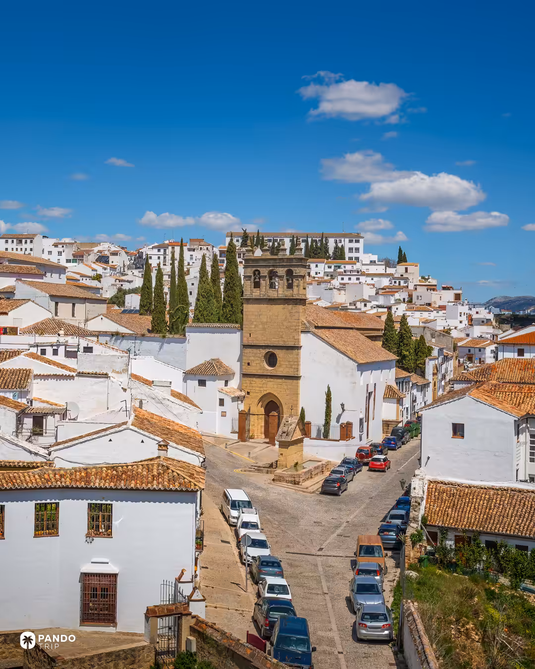 The stone tower of the Church of Padre Jesús among the whitewashed houses of Ronda.