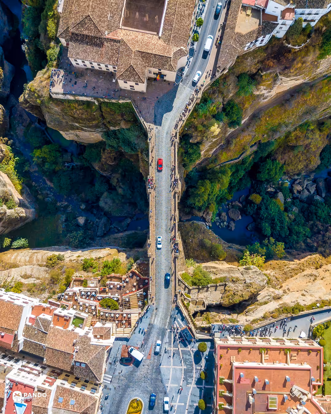 Top-down aerial view of the Puente Nuevo in Ronda, the road across the bridge suspended over the gorge between the old and new town.